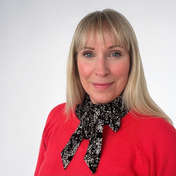 Simply Collars black and white ditsy print collar with a bow tie detail, worn under a red sweater.